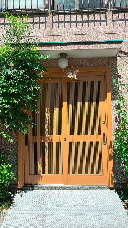 a large orange door on a building at Ryokan Nakadaya in Tokyo