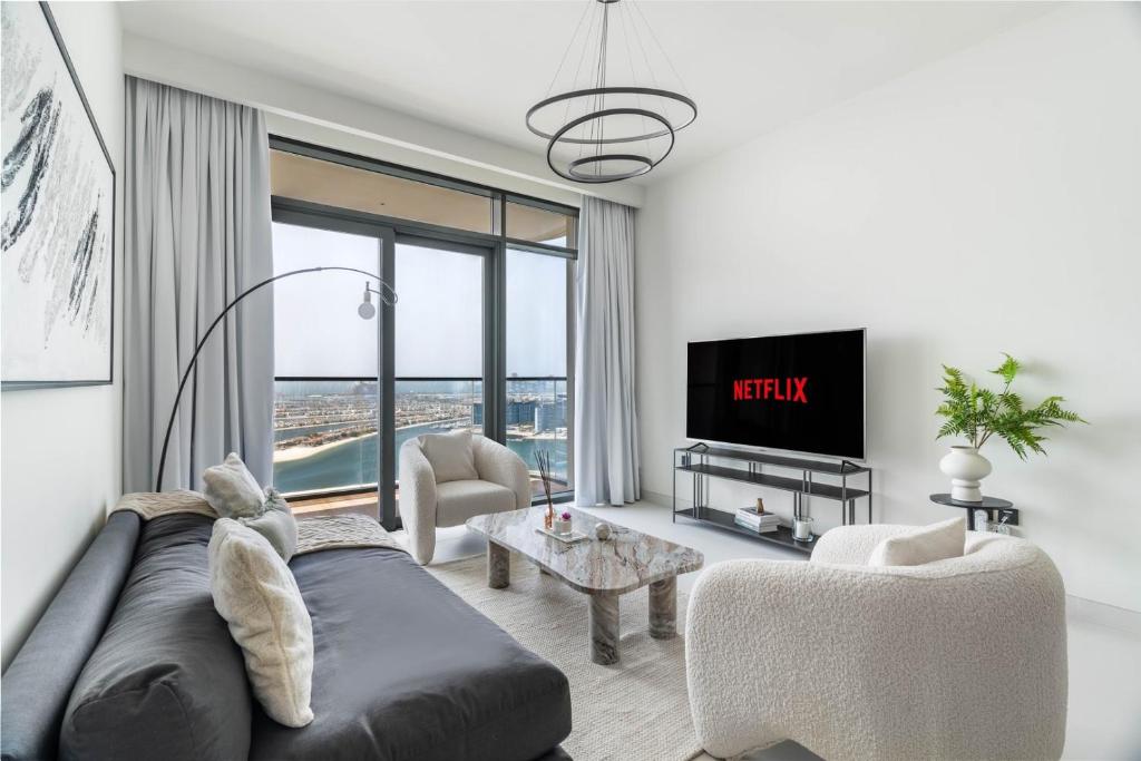 un salon avec un canapé et une télévision dans l'établissement GuestReady - Elegant stay with Palm Jumeirah view, à Dubaï