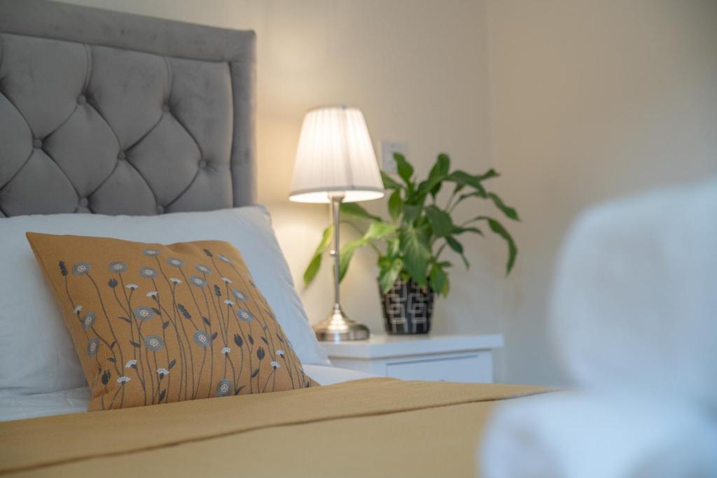 a bedroom with a bed with a lamp and a plant at Steps away from New Street Station & 2 Beds & 2 Baths Flat at City Center in Birmingham