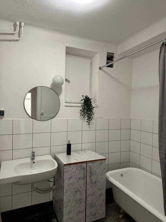 a bathroom with a sink and a tub and a mirror at Nice rooms in City Center Kraków in Kraków