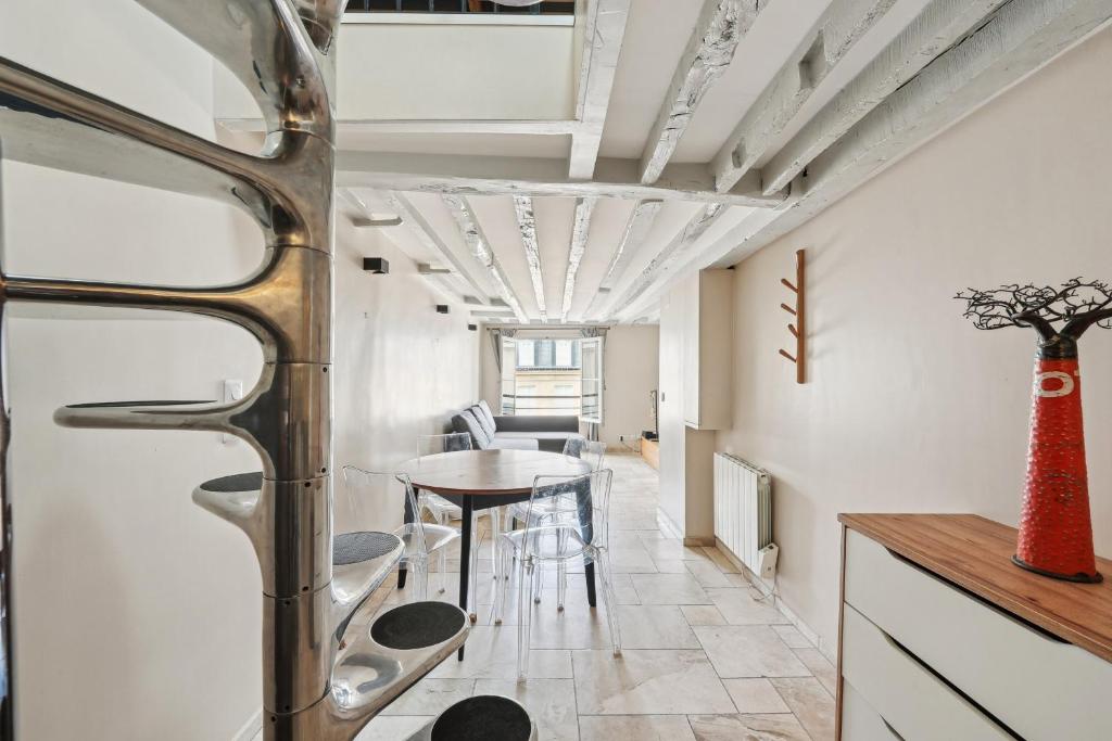 une cuisine et une salle à manger avec une table et des chaises dans l'établissement Orsay Invalides - Lille 1bdr by B'Your Home, à Paris