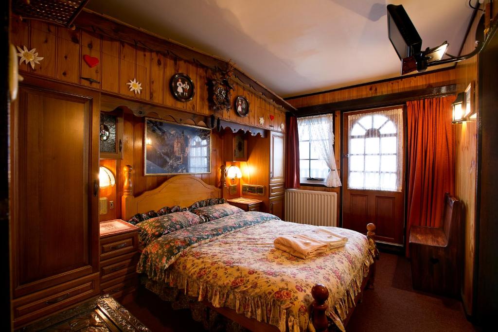 a bedroom with a bed in a room with wooden walls at Karelia Alpine Lodge in Falls Creek