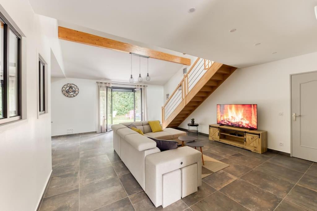 a living room with a white couch and a tv at Grande Maison Luxueuse - Paris - Villepinte in Villepinte