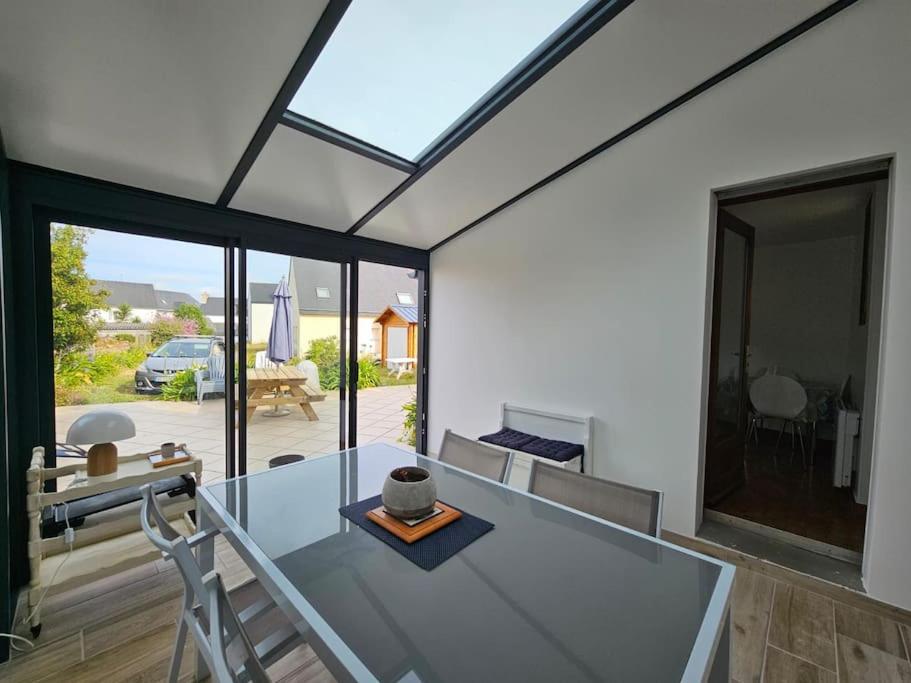une salle à manger avec une table et des chaises en verre dans l'établissement Maison Tregastel Saint-Anne, à Trégastel-Plage