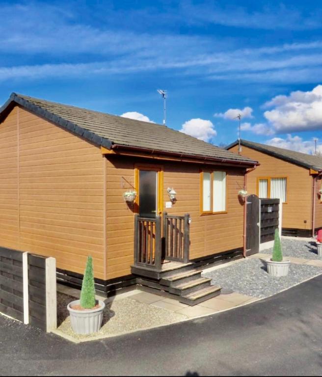 a tiny house with a porch and a driveway at Ivy Cabin with Hot Tub in York
