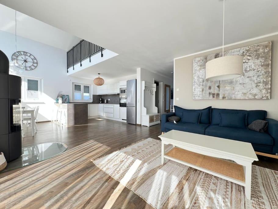 un soggiorno con un divano blu e un tavolo di Ferienresort - idyllisches Ferienhaus mit Privatstrand und Sauna in der Nähe von Leipzig #HausJonas a Löbnitz