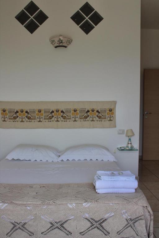białe łóżko z dwoma ręcznikami na górze w obiekcie B&B Sa Clarera w mieście Baunei