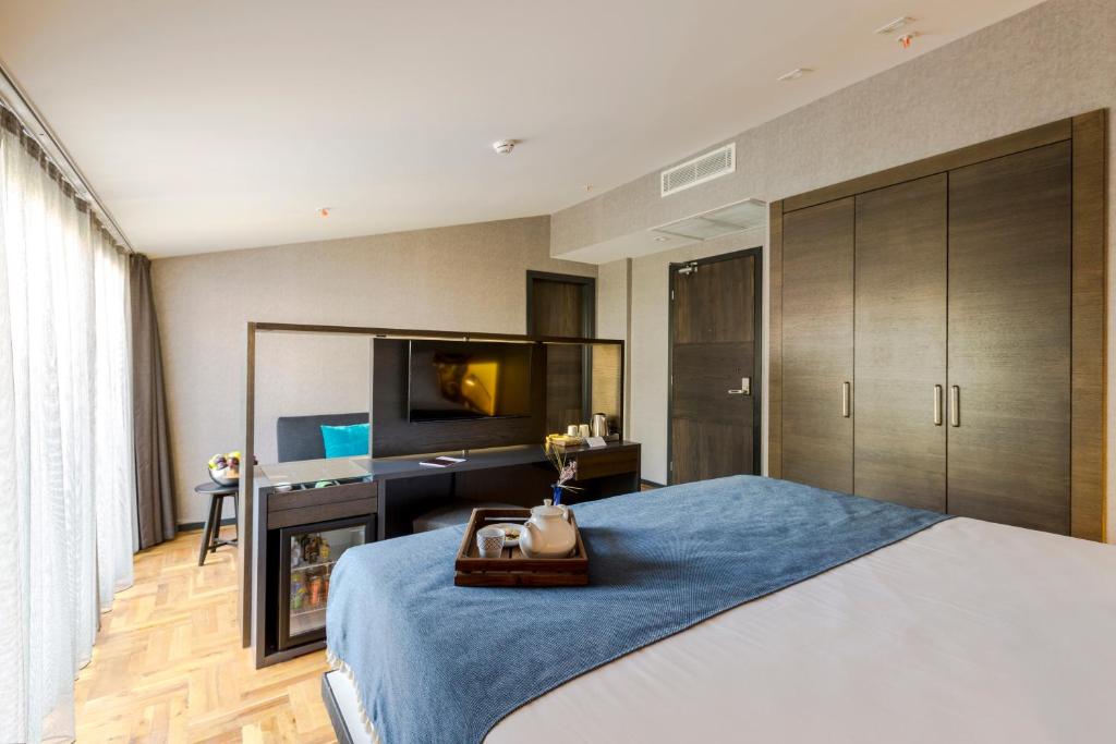 Un dormitorio con una cama con un escritorio y un televisor. en Lampa Design Hotel-Special Category, en Estambul