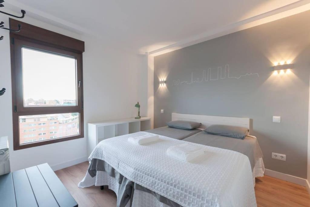Un dormitorio blanco con una cama y una ventana. en ºººCH Residential Area Modern City Views WiFi ACººº, en Madrid