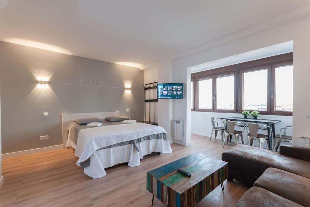 Un dormitorio con una cama y una sala de estar. en ººººCH Residential Area Modern City Views WiFi ACºººº, en Madrid