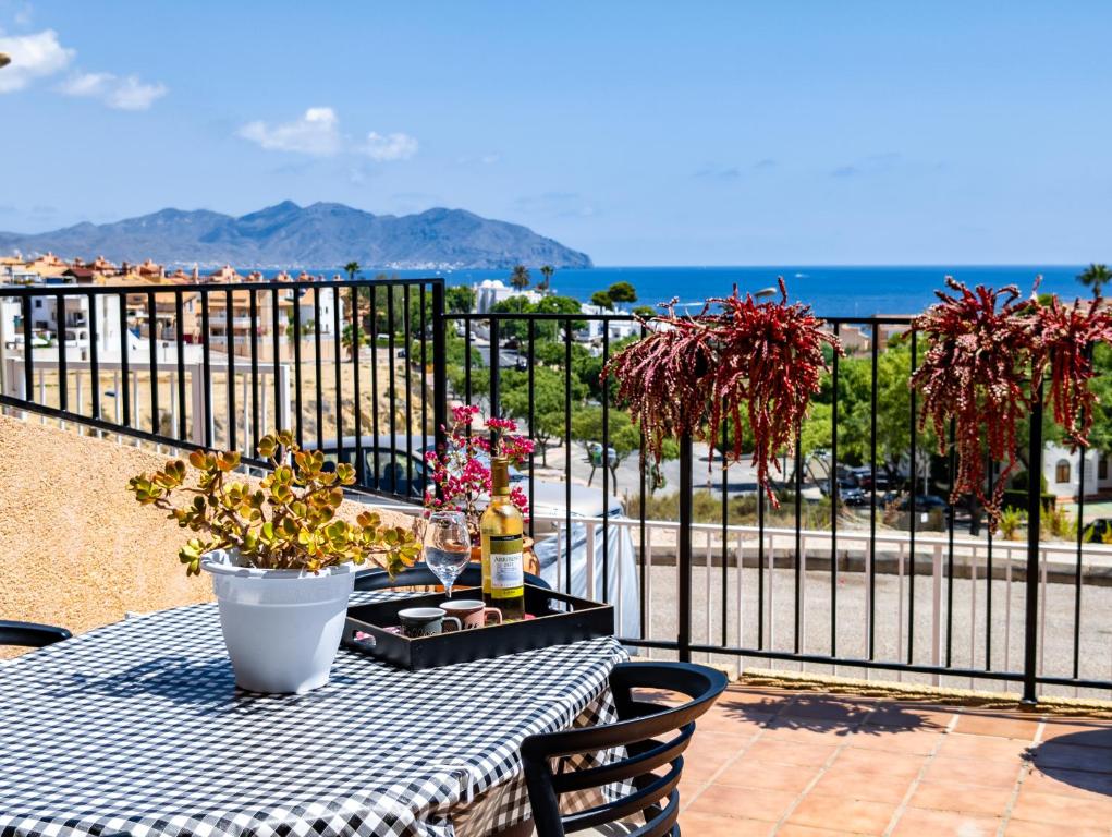 stół z butelką wina na balkonie w obiekcie SunRise Den, a pie de playa, vista al mar y piscina w mieście Puerto de Mazarrón