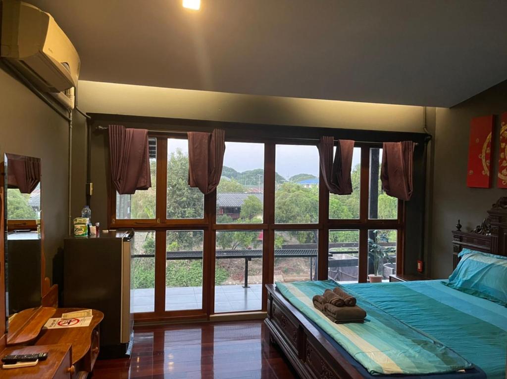 a bedroom with a bed and a large window at Baan mae khian homestay in Phra Nakhon Si Ayutthaya