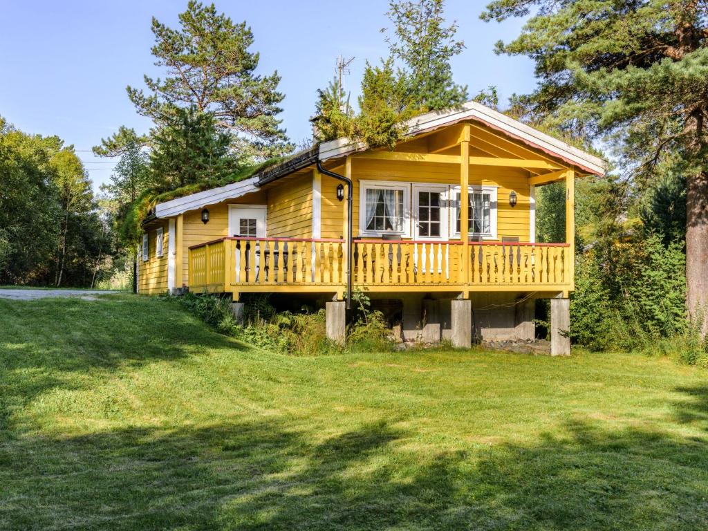 a yellow house with a large yard at Holiday Home Synnøve by Interhome in Gjølanger