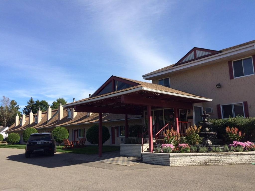 een gebouw met een auto geparkeerd op een parkeerplaats bij Motel des Pentes et Suites in Saint-Sauveur-des-Monts