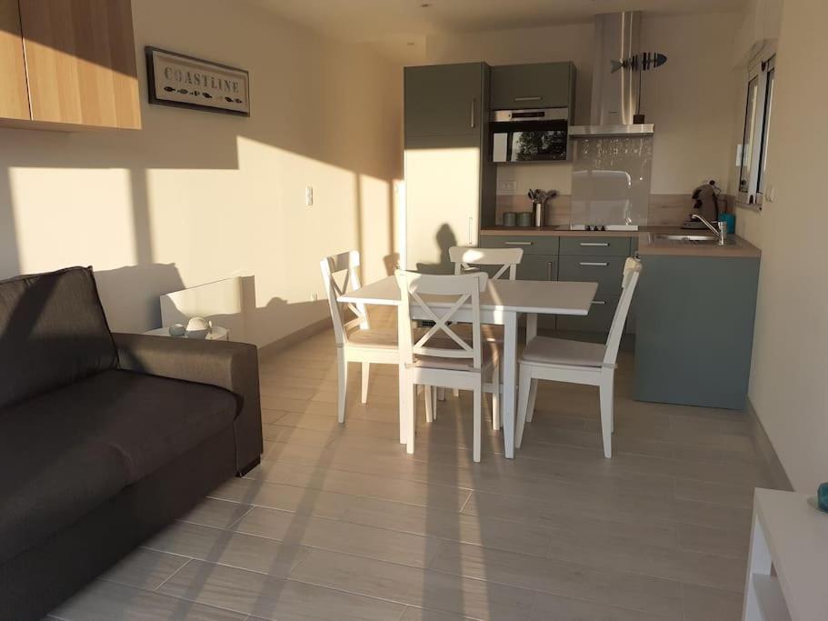 a living room with a table and chairs and a kitchen at Succom'baie au cottage de la Maye in Le Crotoy