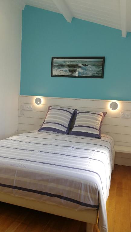 un lit dans une chambre avec un mur bleu dans l'établissement Danae 2, à Saint-Martin-de-Ré