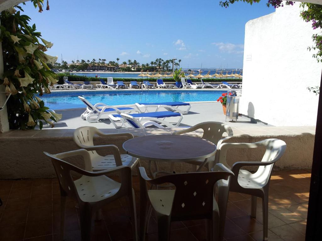 a patio with tables and chairs next to a pool at Carabela in Port d'Alcudia