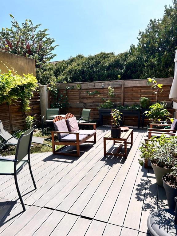 d'une terrasse avec des chaises et des tables dans l'arrière-cour. dans l'établissement Appartement avec terrasse proche centre ville d'Arles, à Arles