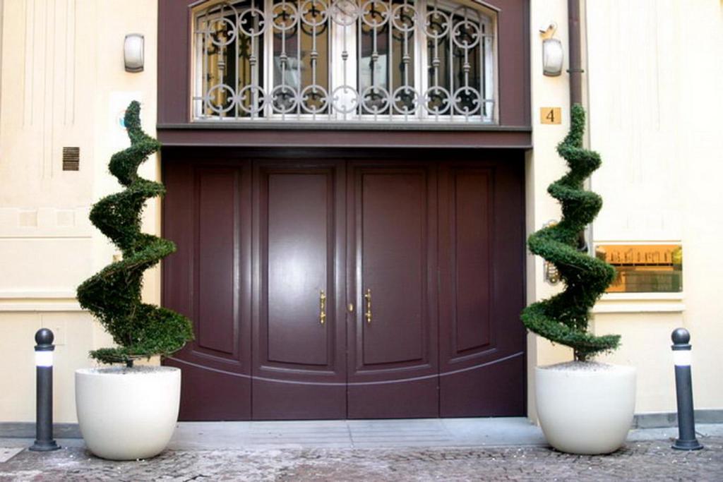 une porte brune avec deux plantes devant elle dans l'établissement IL CASTELLO HOSTEL BOUTIQUE, à Bologne