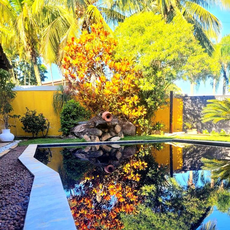 a swimming pool in a yard with trees in the background at A Casa do Sol Ilhabela in Ilhabela
