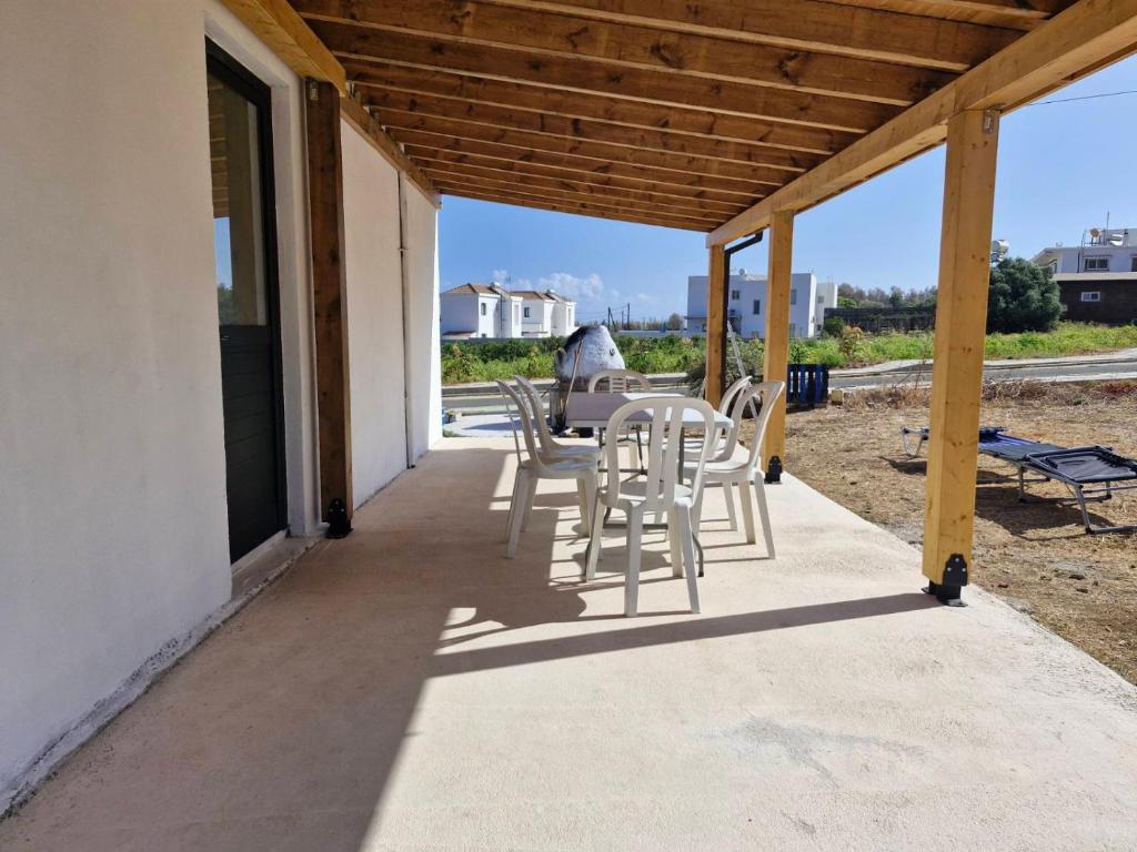 a patio with a table and chairs on it at Pomos rockaway beach house in Pomos