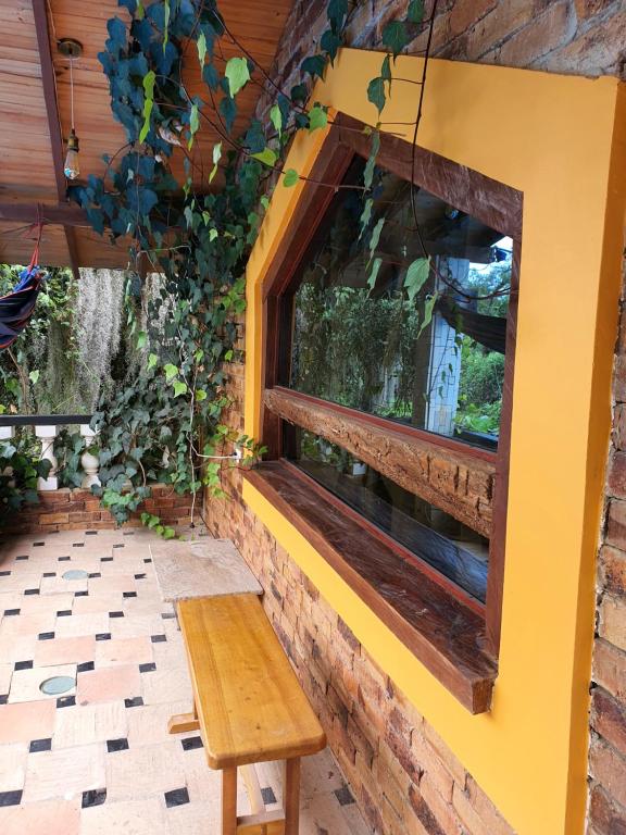 a bench in front of a window in a building at Encantador refugió natural in Santa Rosa de Viterbo