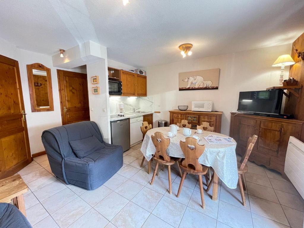 une cuisine et une salle à manger avec une table et une chaise bleue dans l'établissement Appartement au pied des pistes avec balcon, parking et Wi-Fi - FR-1-505-143, à Notre-Dame-de-Bellecombe