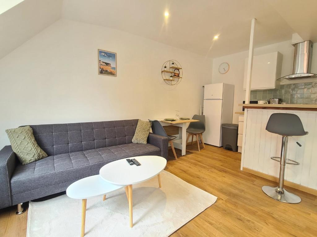 un salon avec un canapé et une table dans l'établissement Le Vert d'Eau - Évasion Authentique au Cœur de Dieppe, à Dieppe