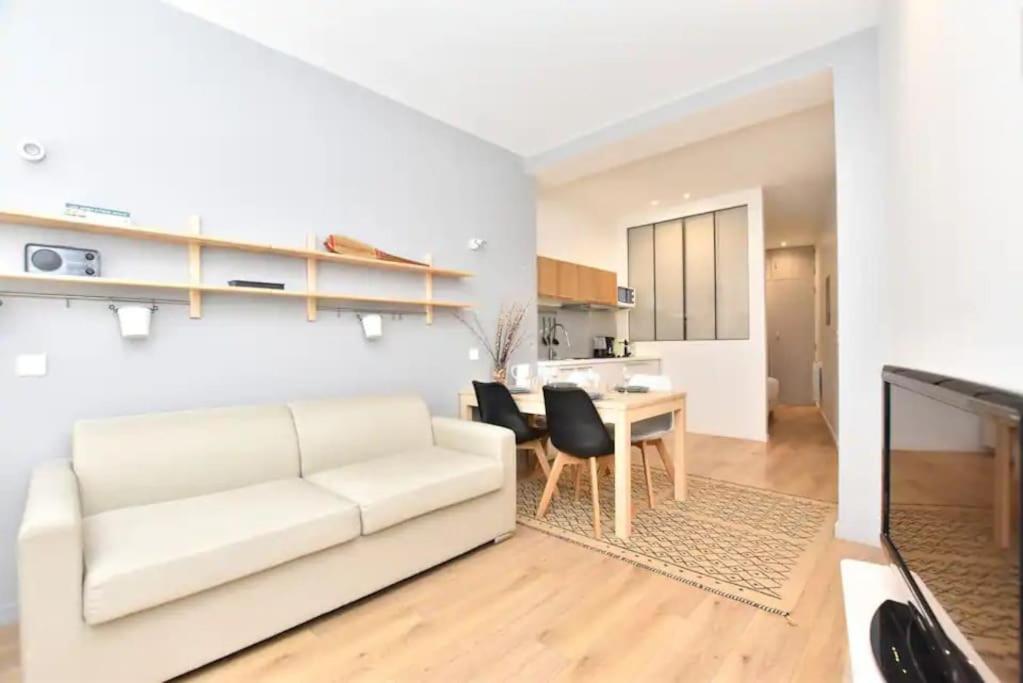 un salon avec un canapé blanc et une table dans l'établissement GoodGuest-Appartement Design et Cosy Batignolles, à Paris