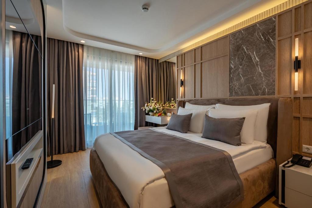 A bed or beds in a room at Awen Lara Hotel