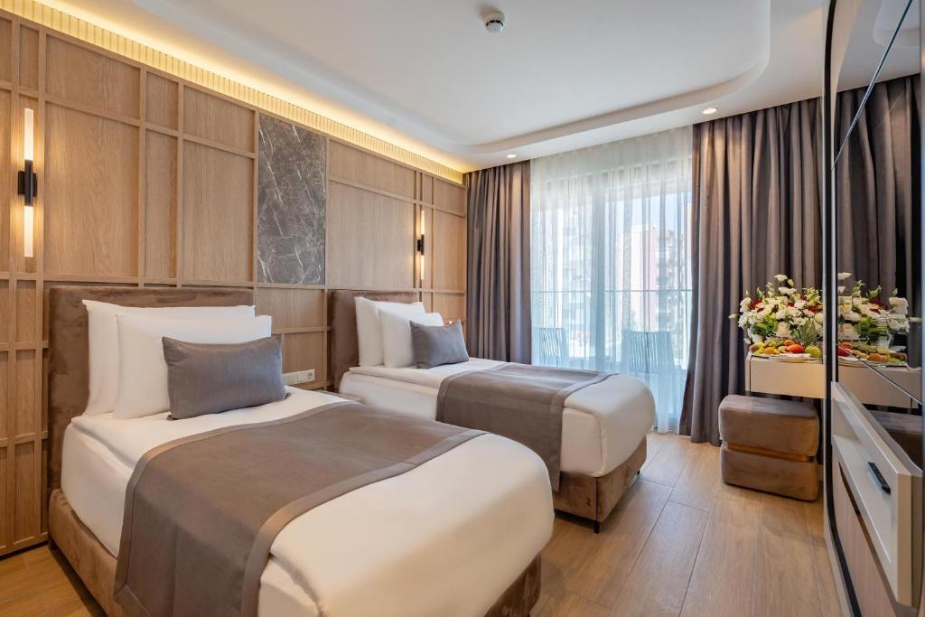 A bed or beds in a room at Awen Lara Hotel