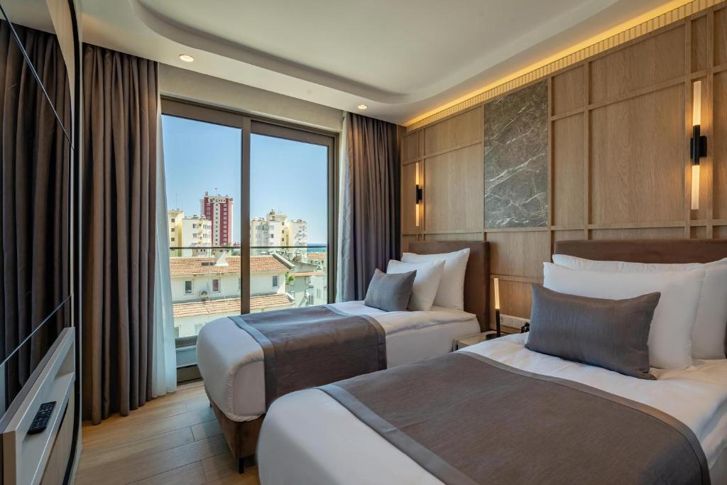 A bed or beds in a room at Awen Lara Hotel