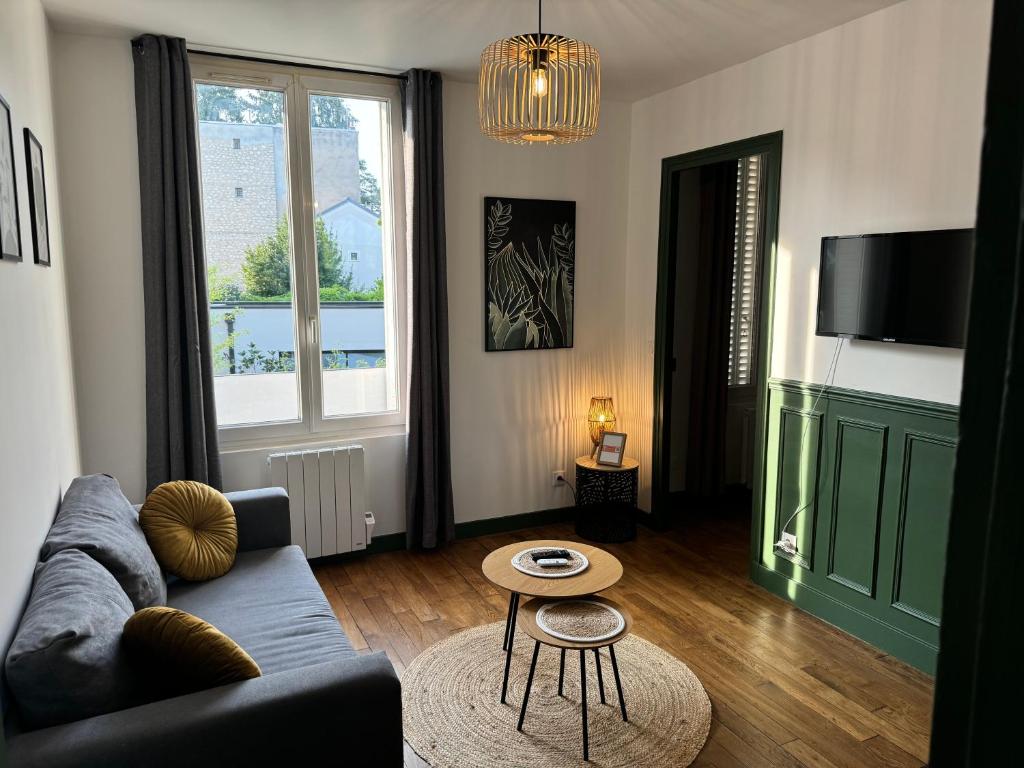 un salon avec un canapé et une table dans l'établissement Appartement calme et lumineux, à Fontainebleau