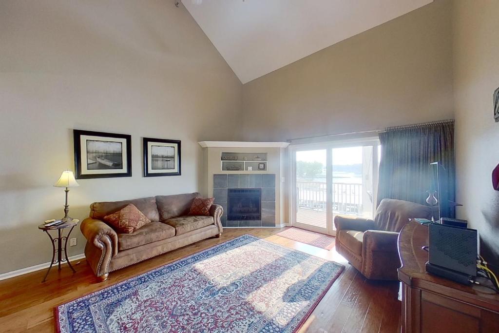 Una sala de estar con un sofá y una chimenea. en Lakeside Lookout, en Sunrise Beach