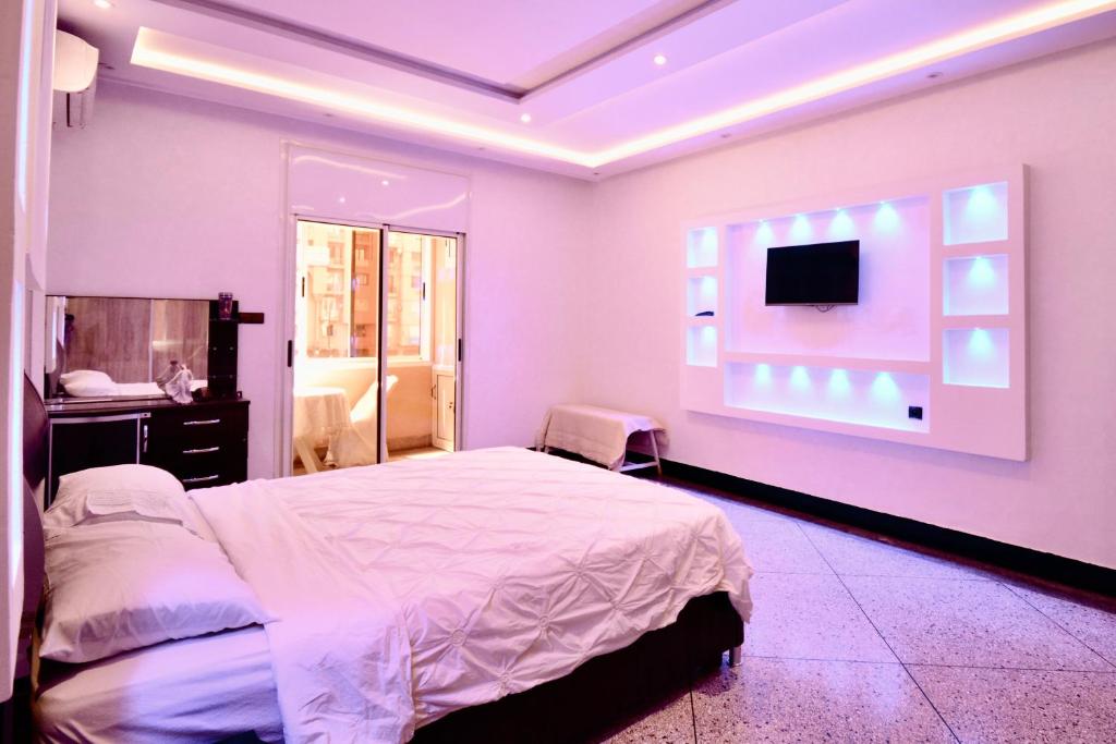 Un dormitorio con una cama y un televisor de pantalla plana. en Chez Abdou, en Marrakech