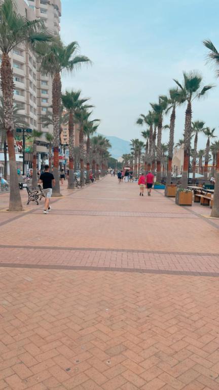 a sidewalk with palm trees and people walking on it at Luxury Apartment in Fuengirola