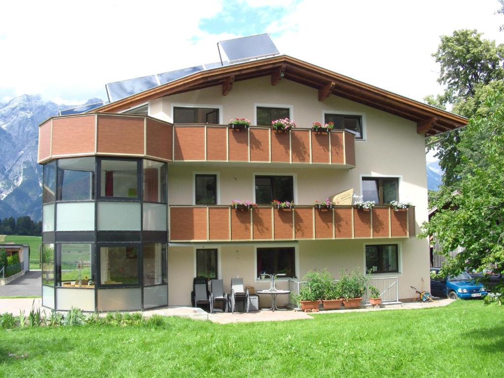 a large house with a balcony and mountains in the background at Ferienwohnung Mair in Innsbruck