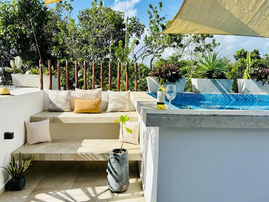 a patio with a bench and a swimming pool at Private Rooftop Pool - Bike to Ruins or Beach in Tulum