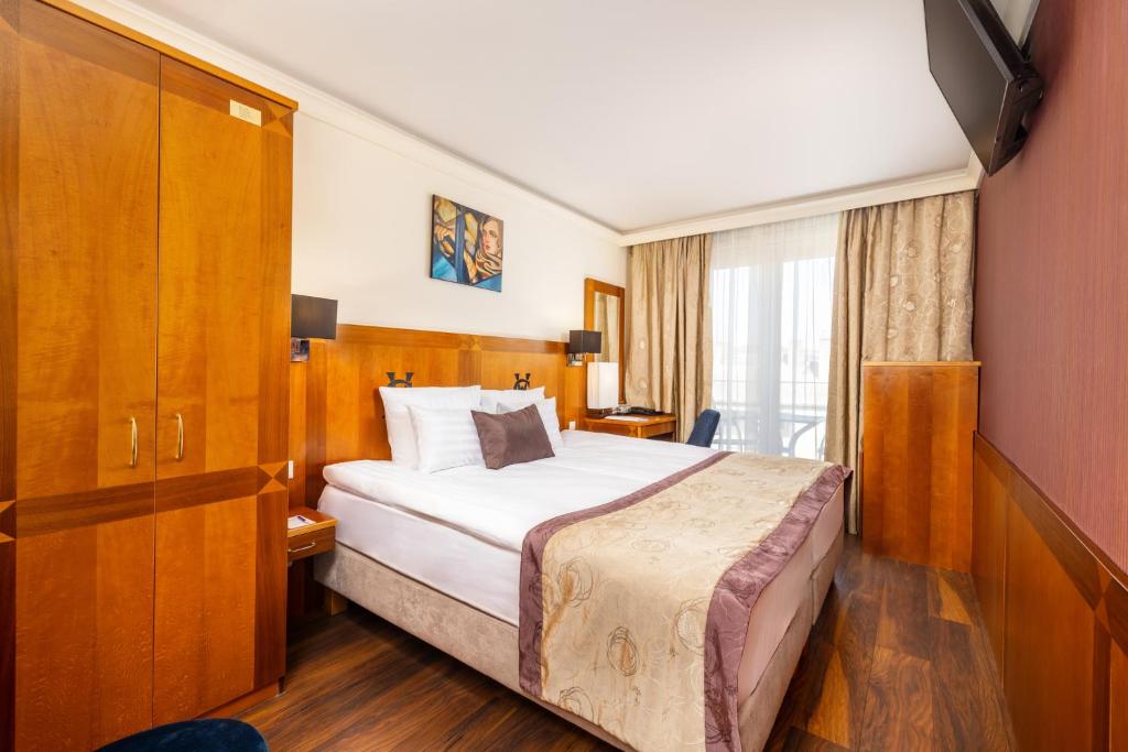 Postel nebo postele na pokoji v ubytování Carlton Hotel Buda Castle