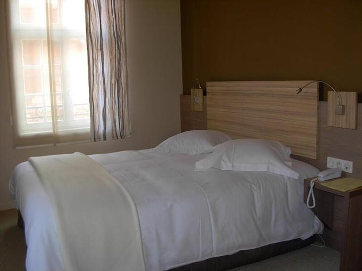 Postel nebo postele na pokoji v ubytování Hostellerie au Cygne
