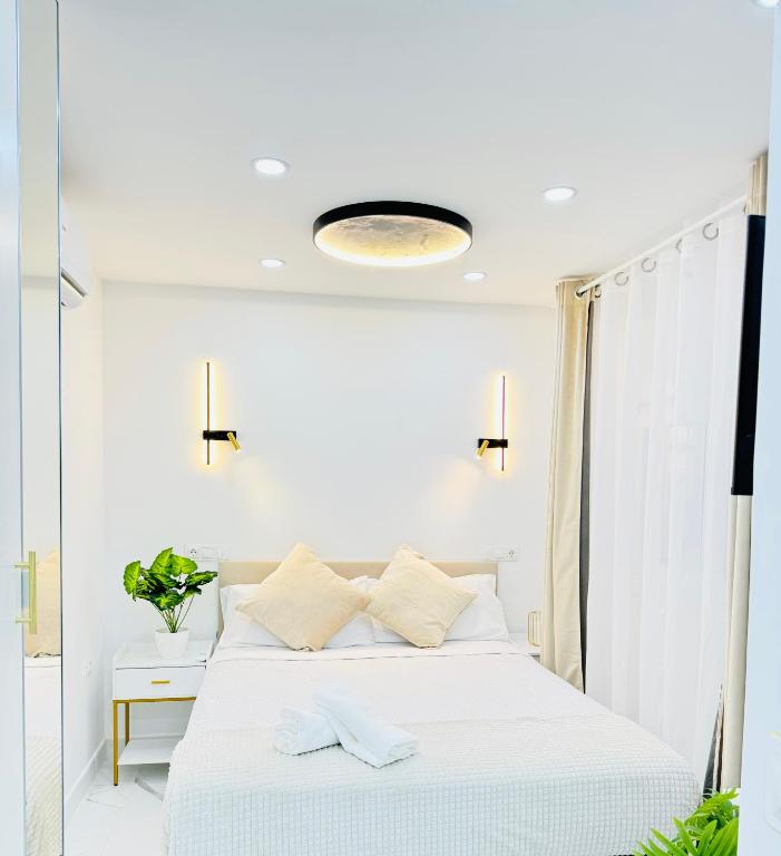 a bedroom with a bed with white sheets and a window at Fuenlabrada in Fuenlabrada