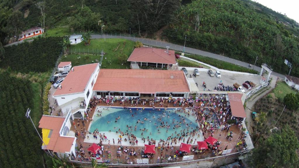 a large crowd of people standing around a swimming pool at Sky Club Eco Hotel in Belén de Umbría