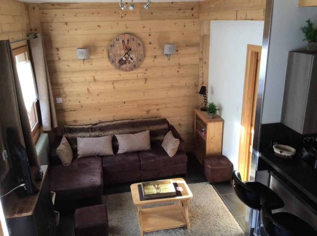 un salon avec un canapé et une horloge au mur dans l'établissement Résidence Aux Sports - 4 pièces 6 personnes 3 exposé est MAE-6224, à Valloire