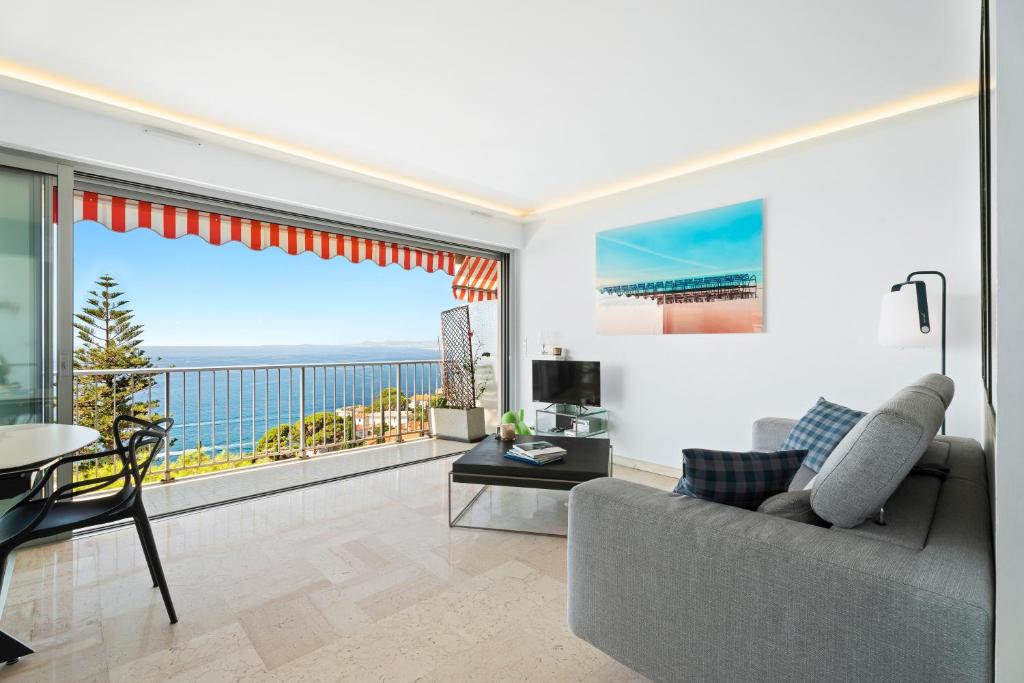 un salon avec un canapé et une vue sur l'océan dans l'établissement Balcon sur la Méditerranée, à Nice