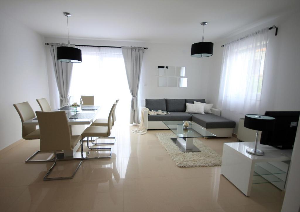 een woonkamer met een bank en een tafel bij Apartments Villa Mantinela in Malinska