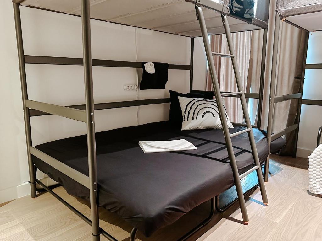 Ce lit superposé se trouve dans un dortoir avec une échelle. dans l'établissement Beds In Shared Apartment - Beograd na vodi Shared Bedrooms In Shared Apartment, à Sajmište