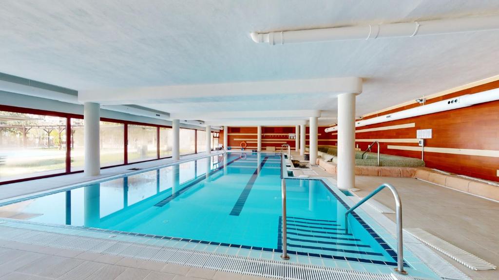 ein großer Pool mit blauem Wasser in einem Gebäude in der Unterkunft Balnea Experiences - Apartamentos con Piscina Exterior, Jacuzzi y Gimnasio in Archena