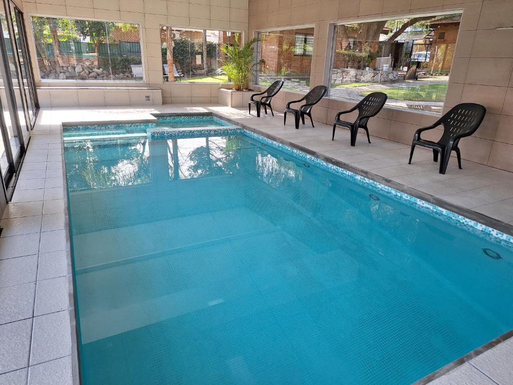 Una gran piscina con sillas en un edificio. en Complejo Brisa Serrana, en Merlo