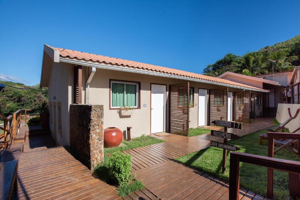 a house with a wooden deck in the yard at Pousada Tubarão in Fernando de Noronha