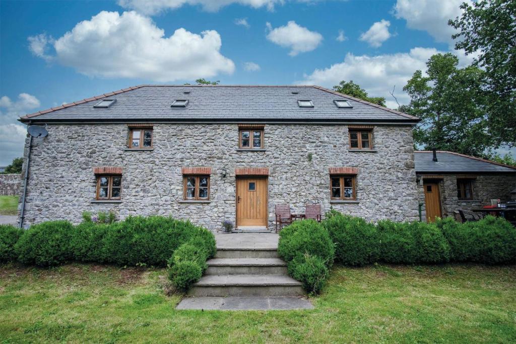 a stone house with a staircase in front of it at The Stables - 3 Bedroom Cottage - Beavers Hill in Manorbier